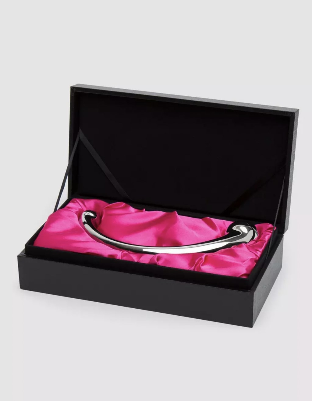 The silver dildo resting in its pink satin cushion in black case