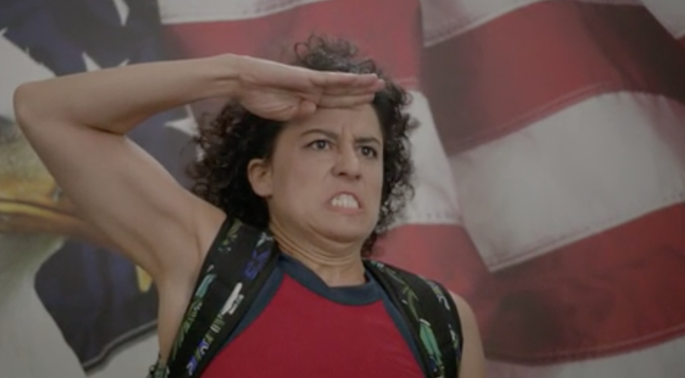 Ilana raising her hand to her head and saluting the American flag
