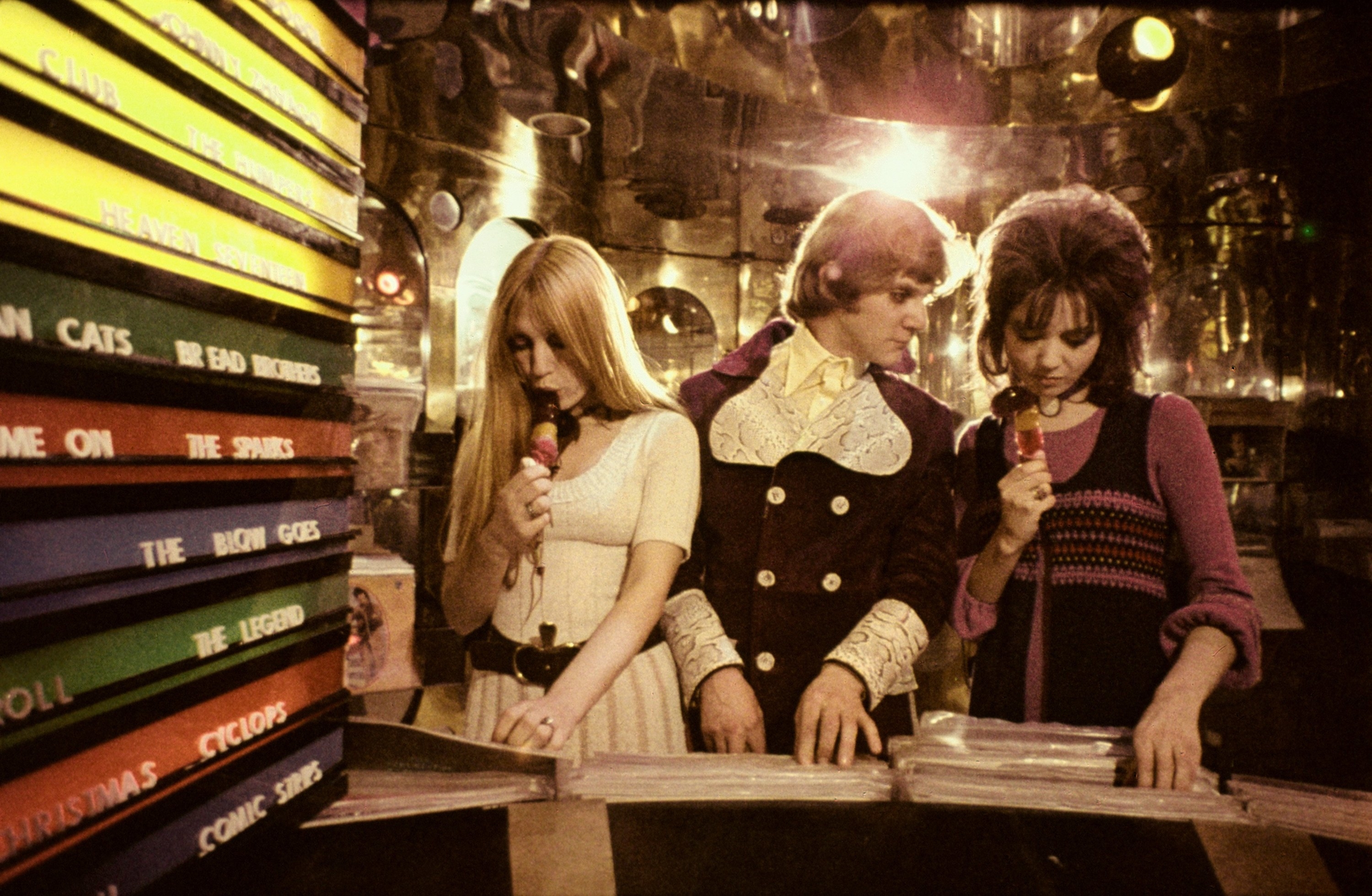 A still of actor Malcolm McDowell standing next to two women in A Clockwork Orange