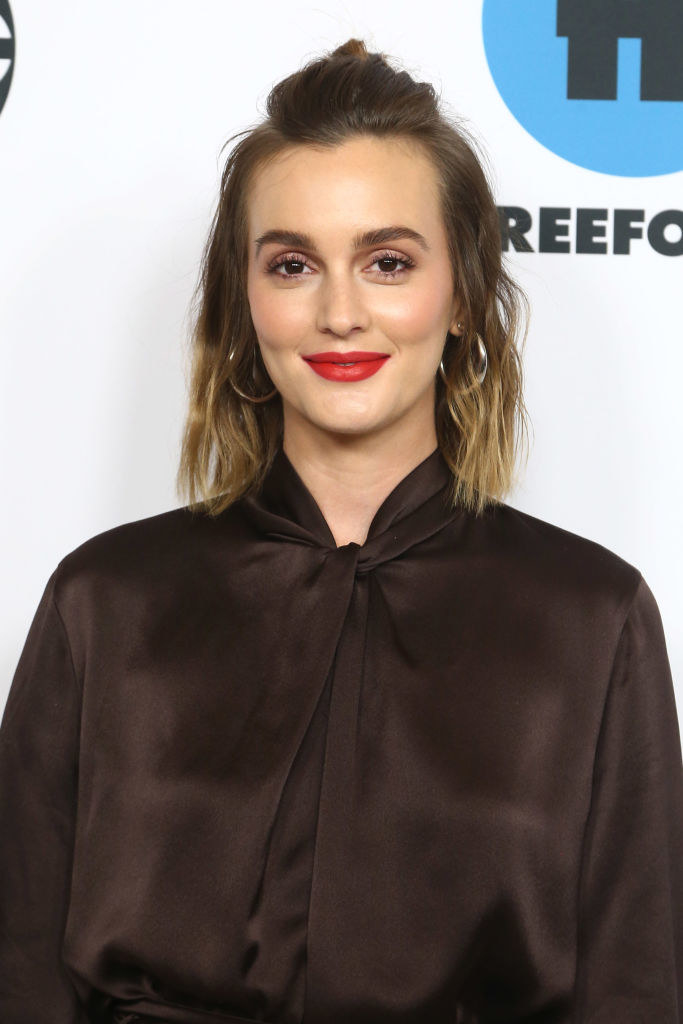 Leighton smiling on the red carpet wearing a satiny blouse