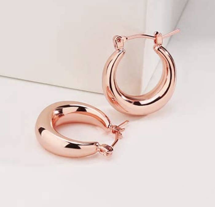 The earrings on a neutral surface and background