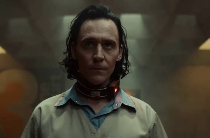 A close up of Loki in a prison jumpsuit and a metal collar