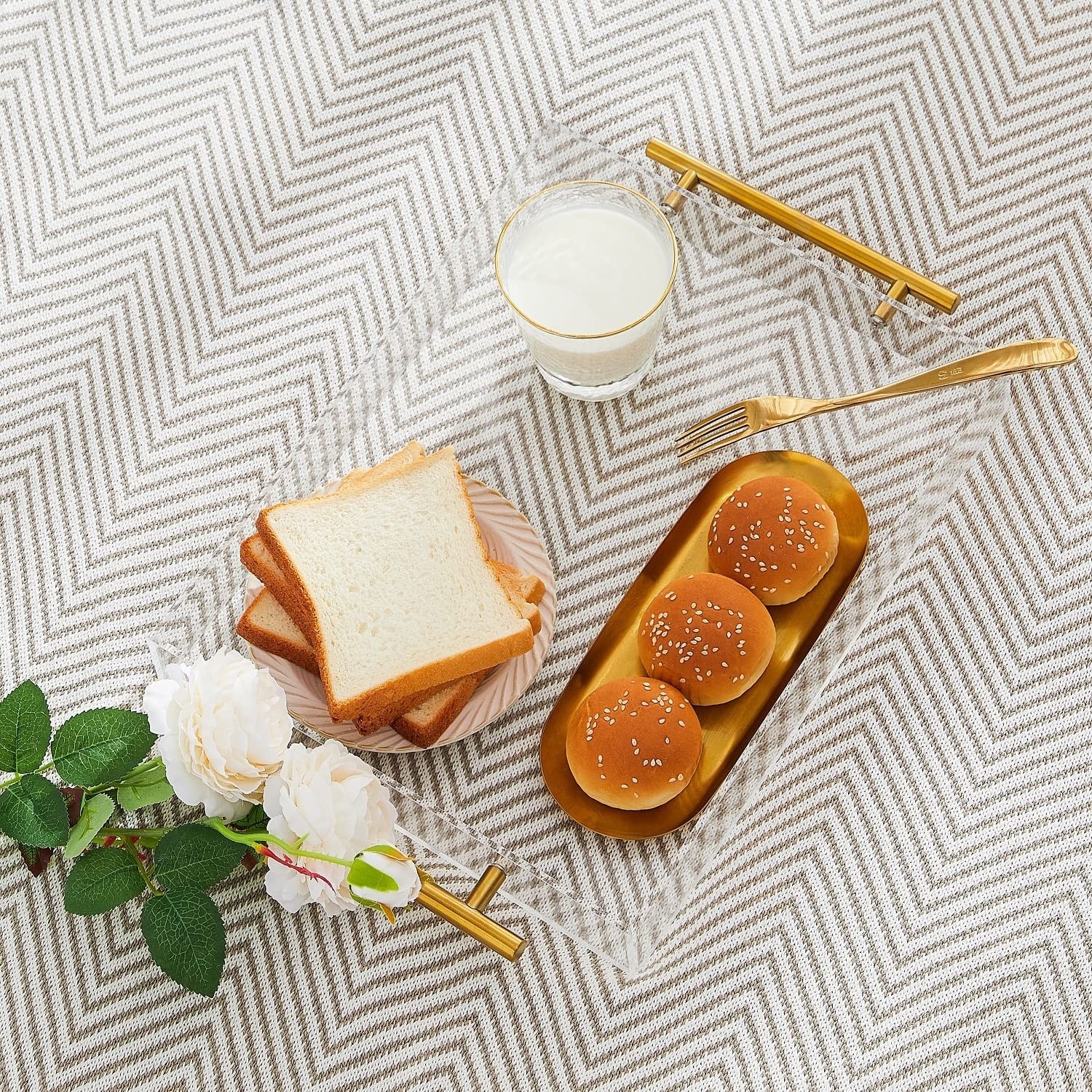 The tray on a chevron carpet with bread, buns, and milk on it