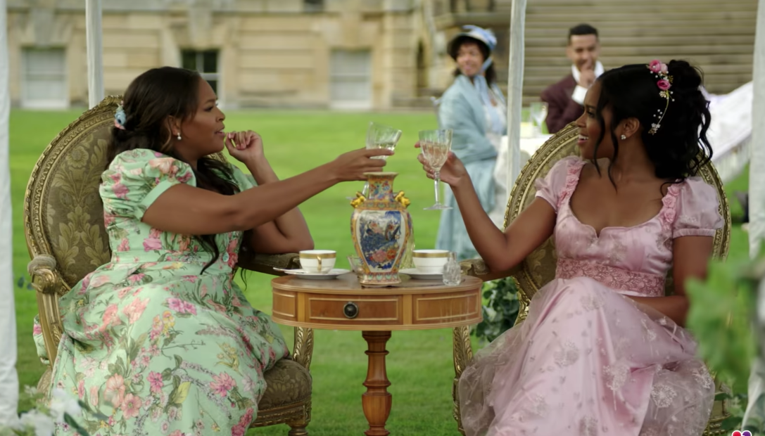 Two women in garden dresses cheers wine glasses