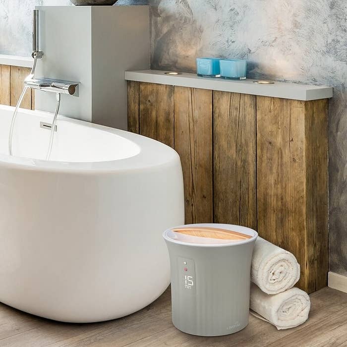 The towel warmer sits next to a freestanding tub