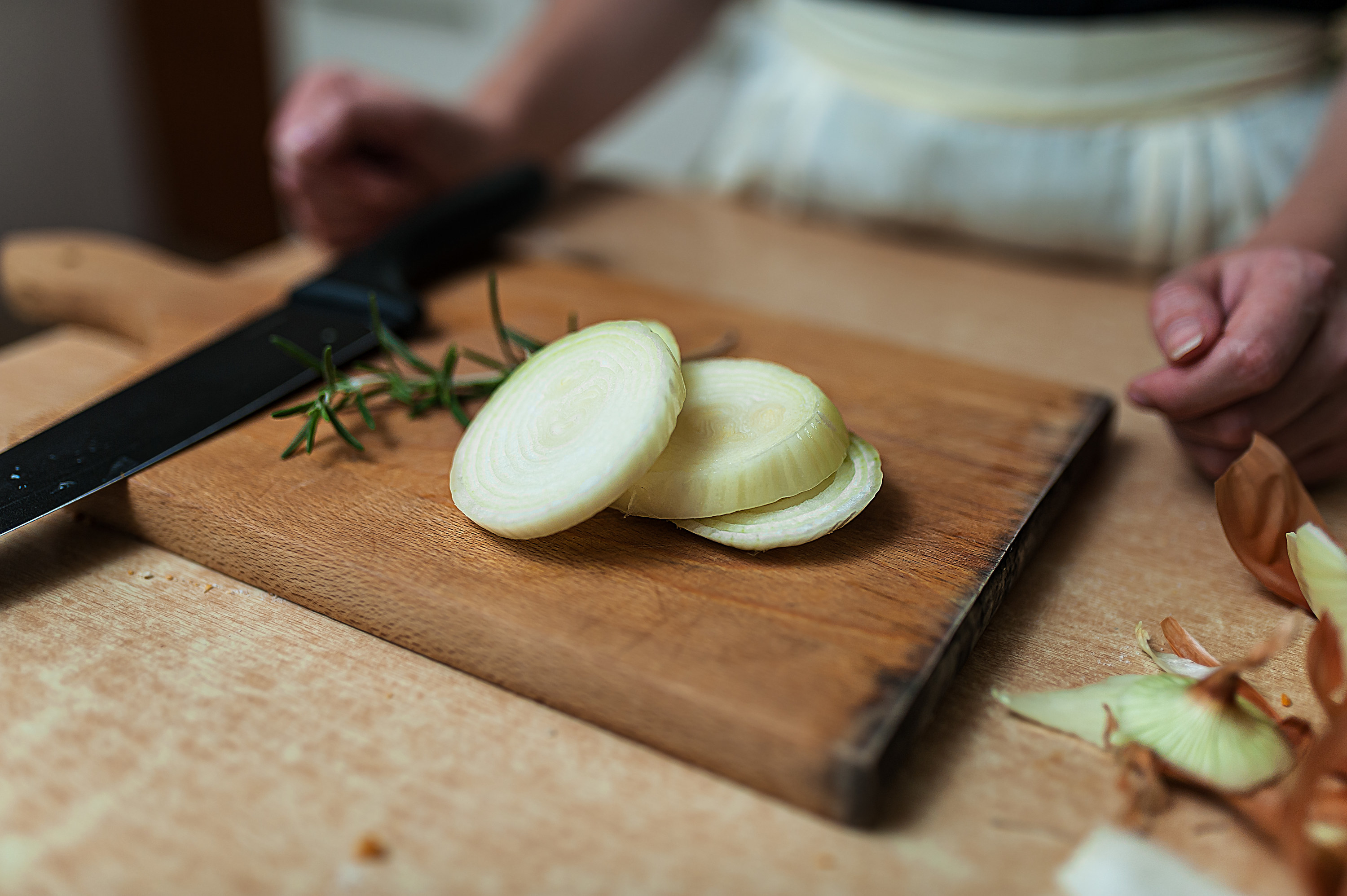 Round slices of onions with herbs on a cutting board
