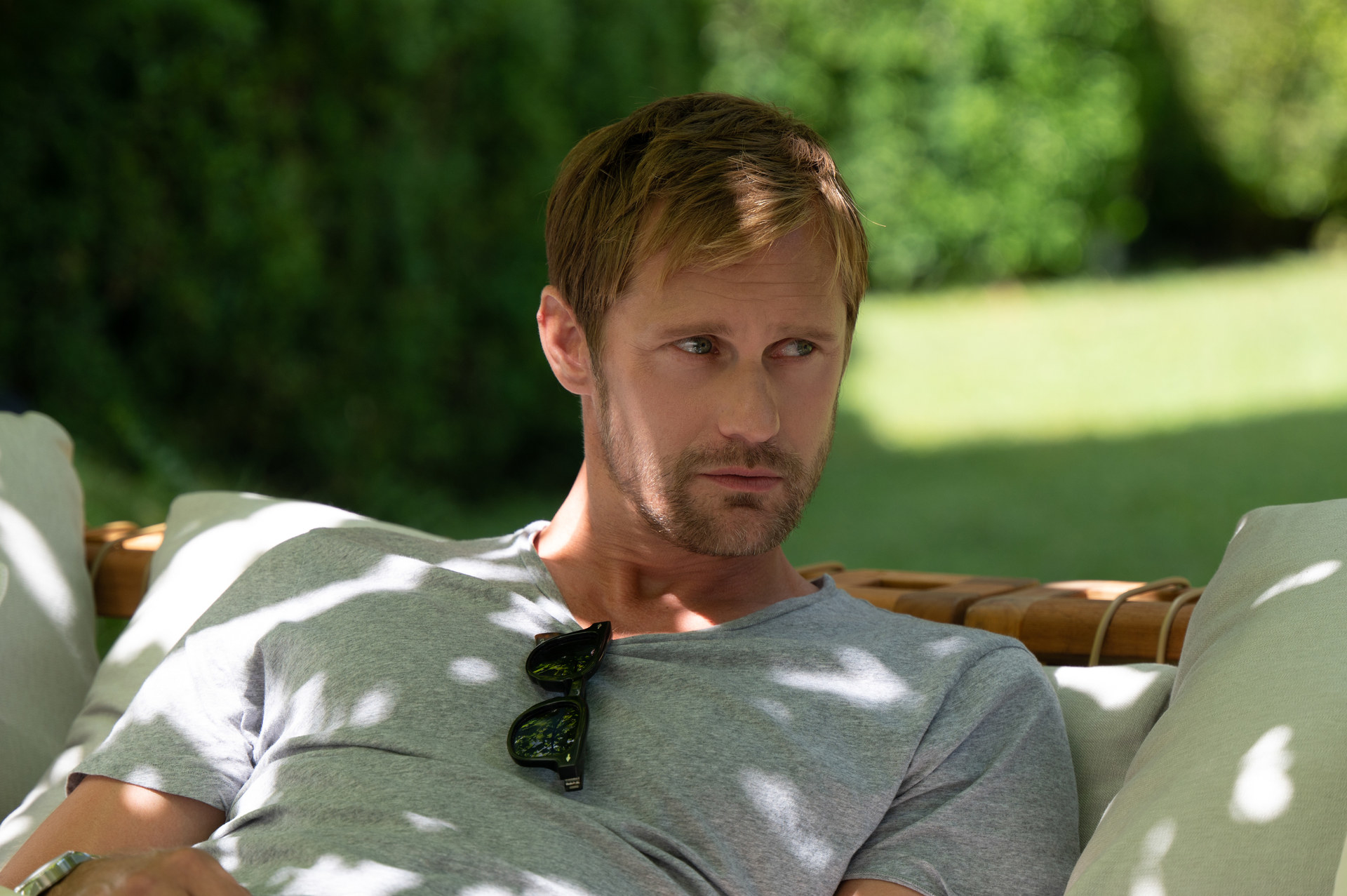 Alexander Skarsgard reclines on a couch