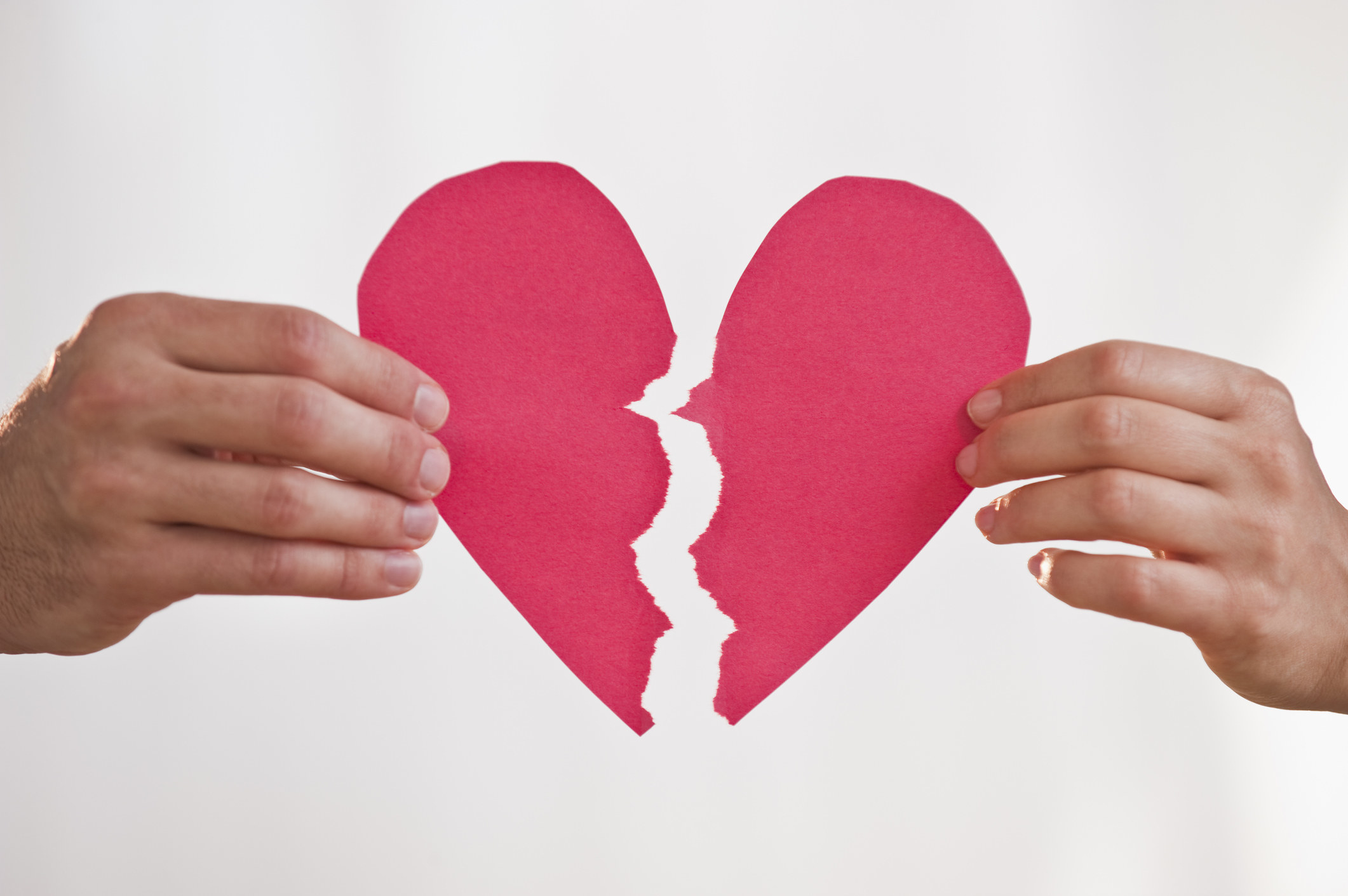 someone tearing apart a paper heart