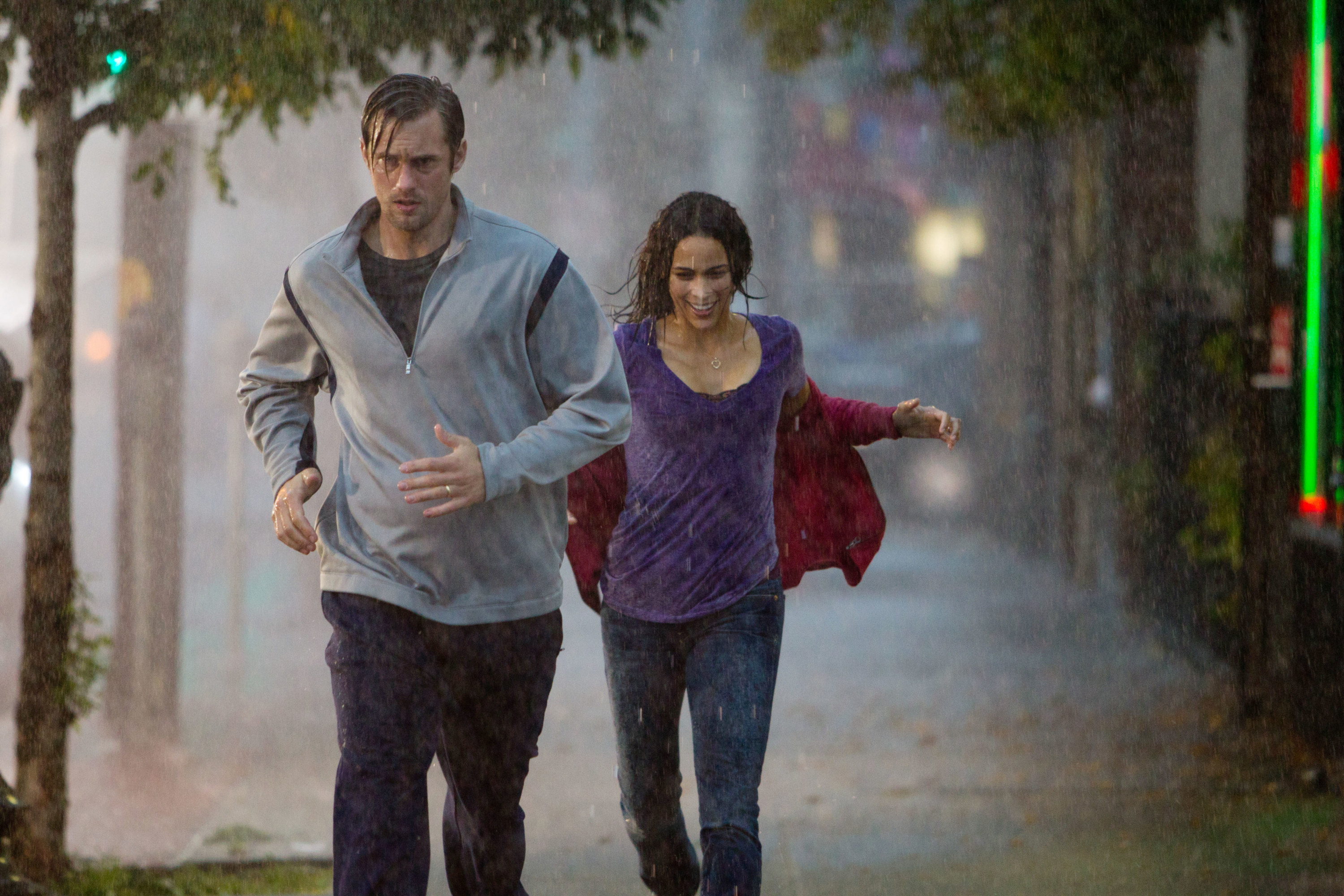Alexander Skarsgard and Paula Patton run in the rain