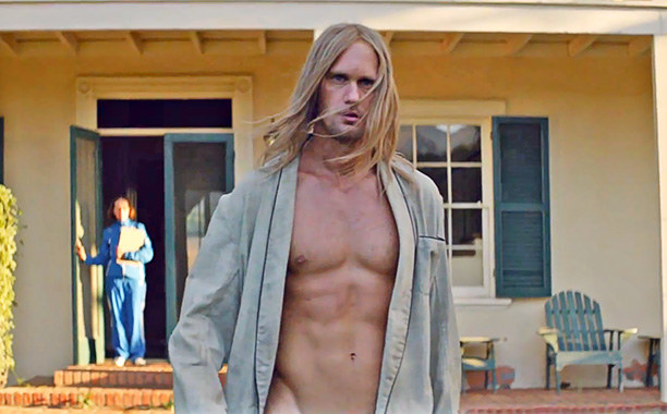 Alexander Skarsgard walks outside in a robe with no shirt on