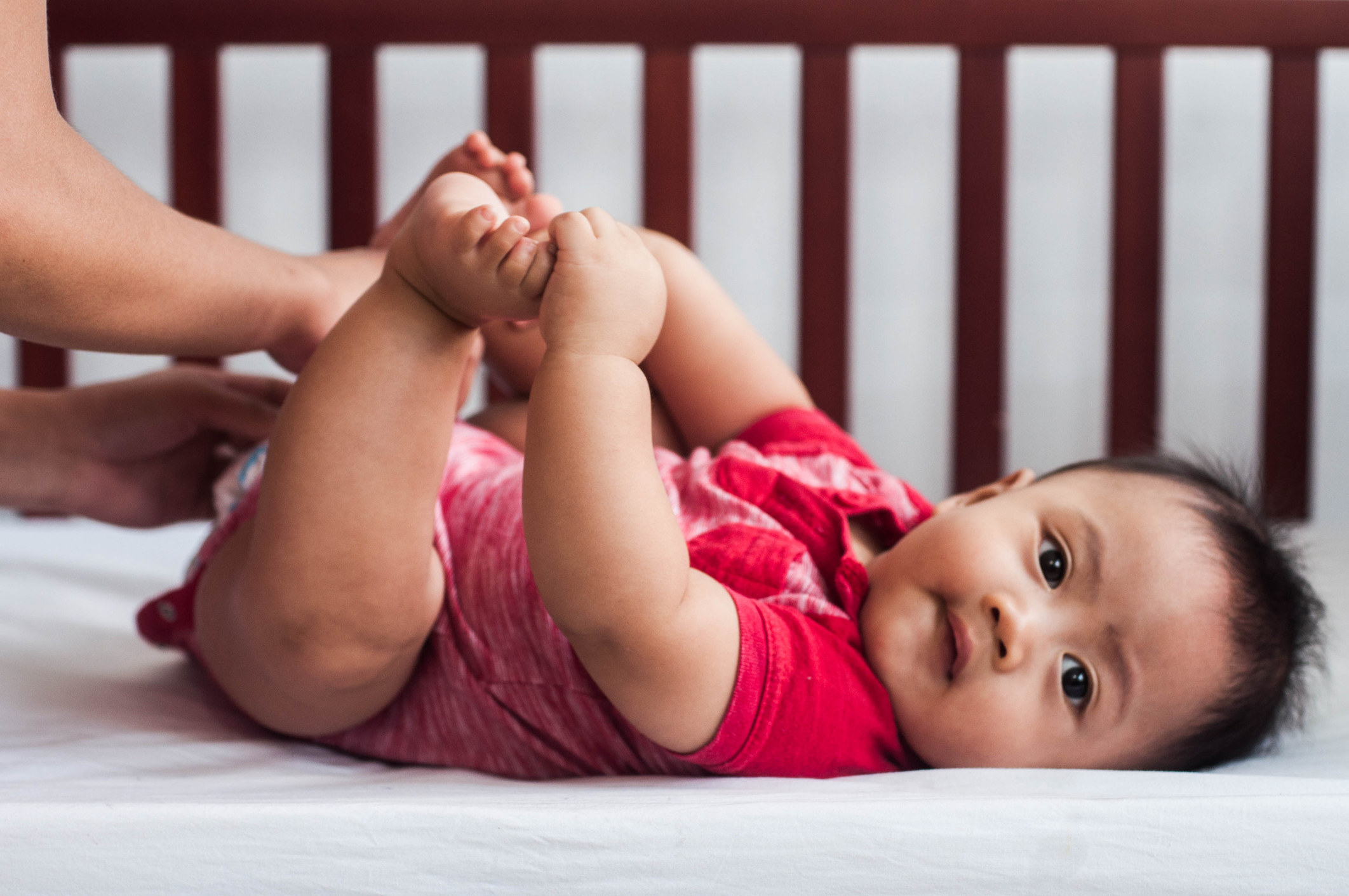 a baby getting dressed in their crib