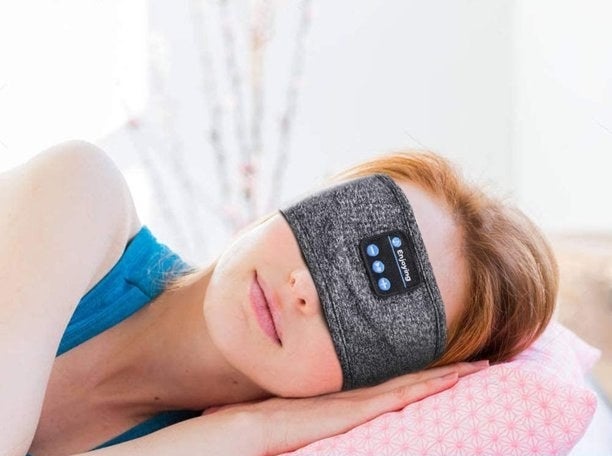 Model sleeping on pillow with the headband over eyes. caption bubble reads "3 in 1, sleep headphones, bluetooth eye mask and bluetooth sports headband