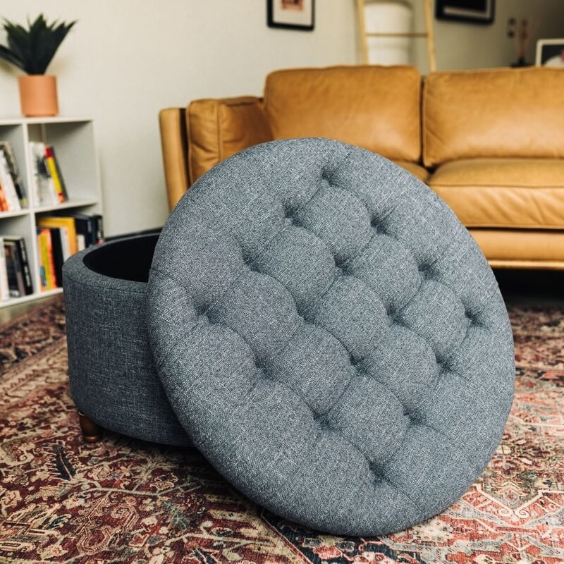 The gray storage ottoman pictured in a living room