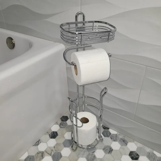 A  silver toilet paper holder with a top basket