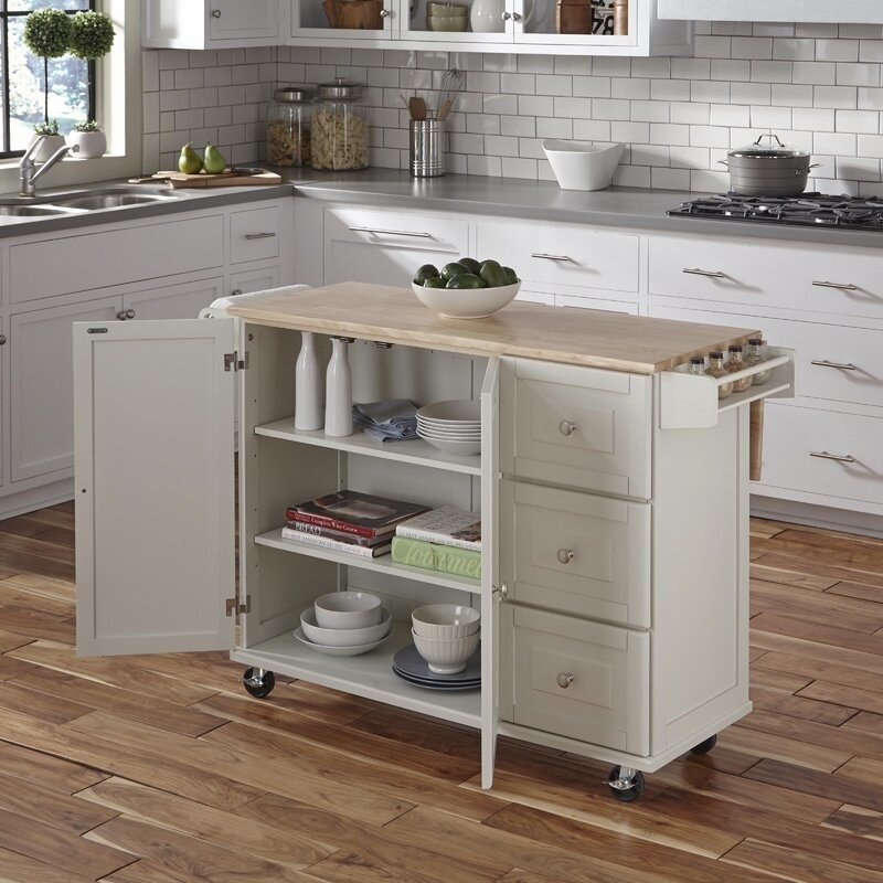 The island in the off-white color with the cabinet open to show storage