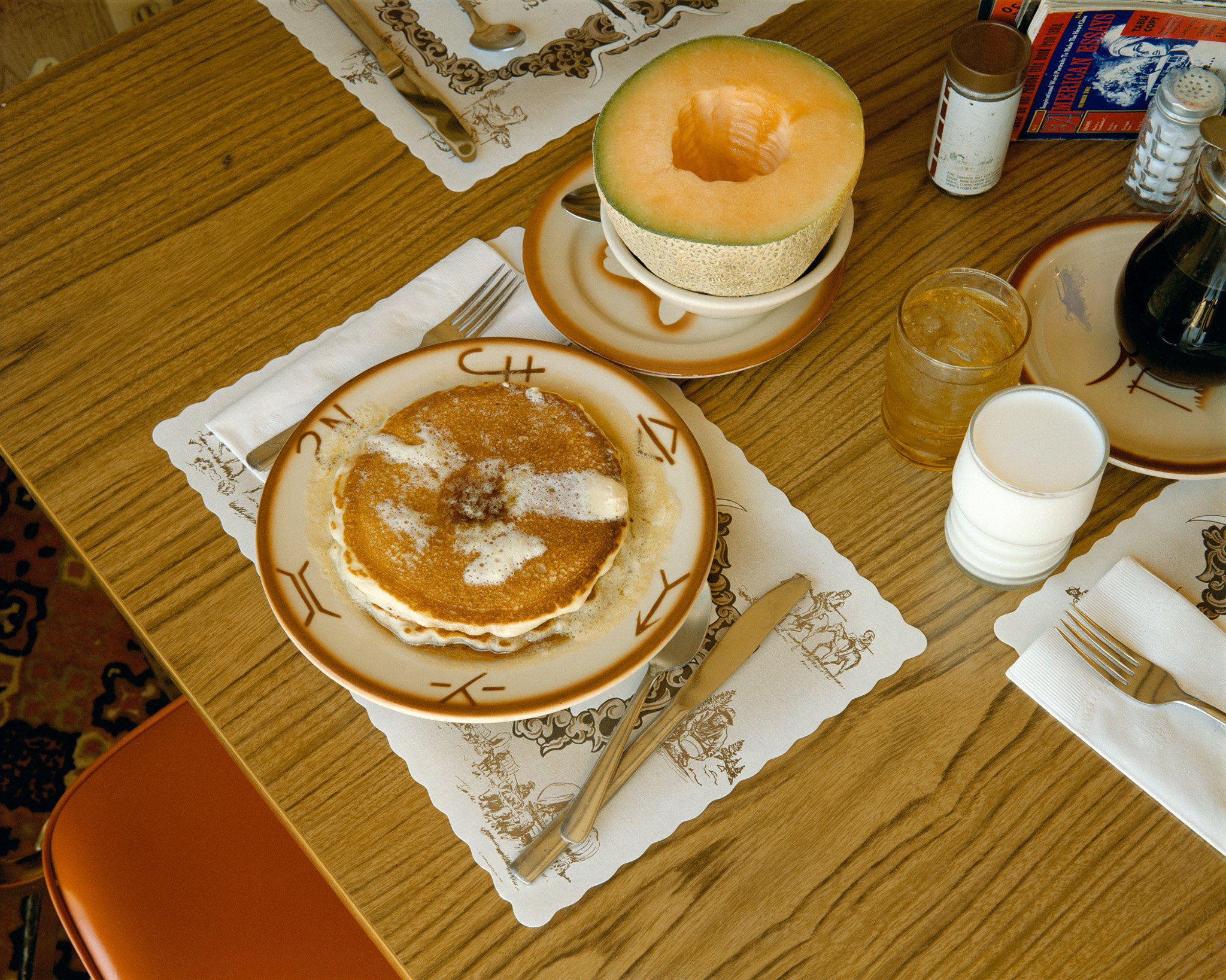 Pancakes, a melon, coffee, and juice at a restaurant