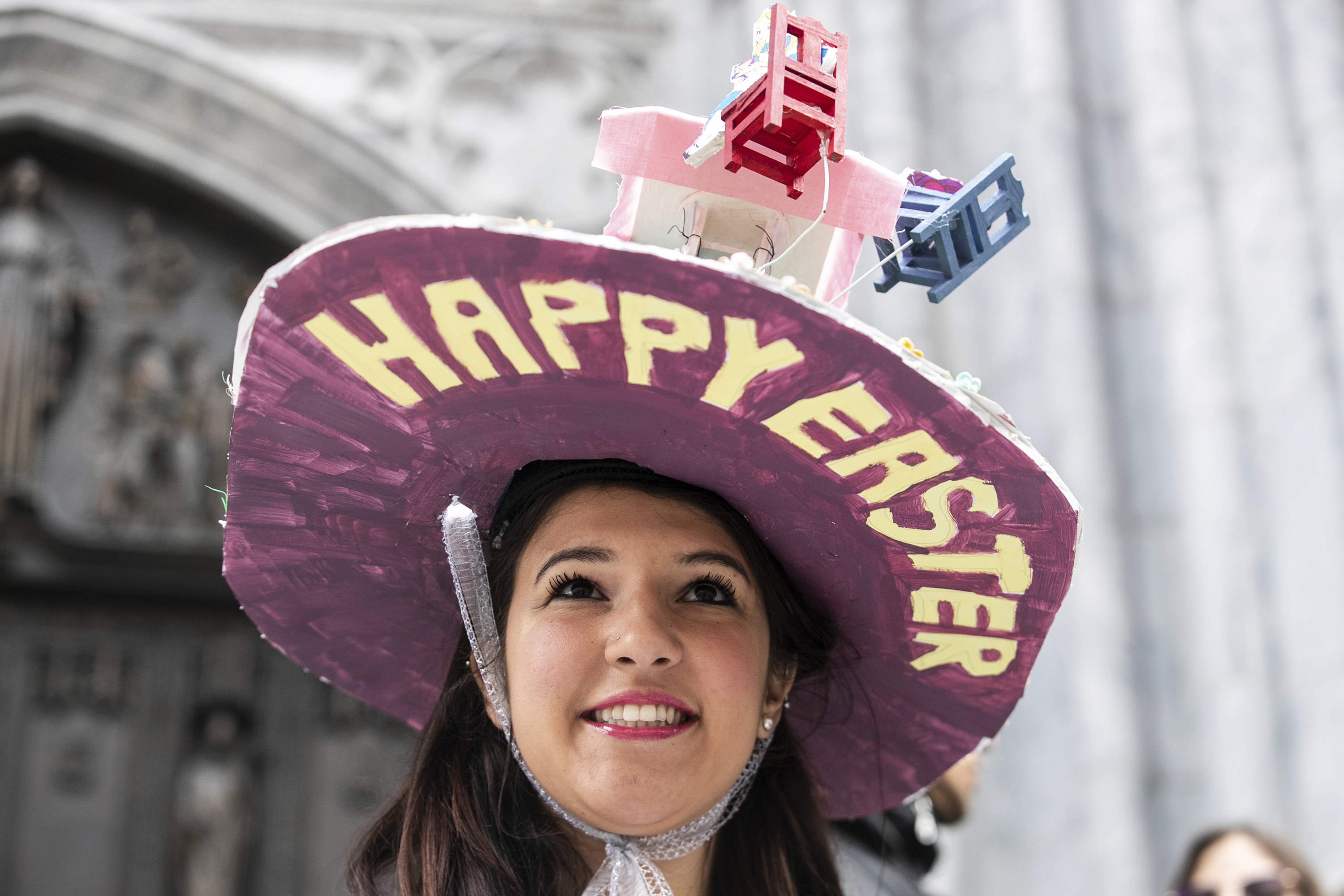 A woman wearing a large hat that says Happy Easter