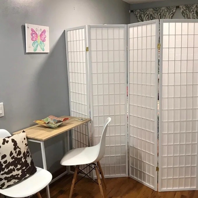 a white room divider separating a desk from the other part of a reviewer&#x27;s home