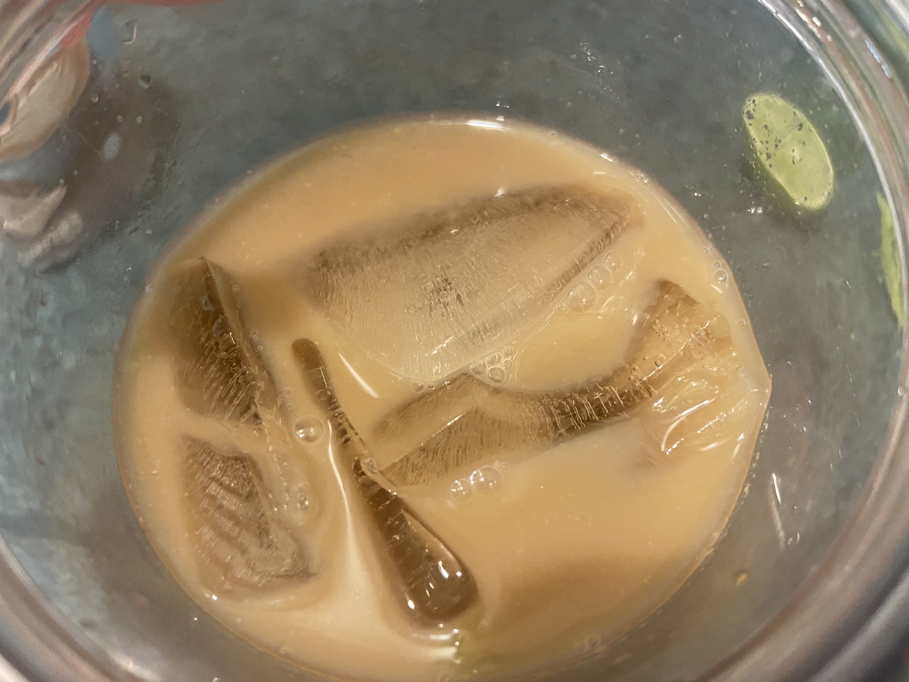 An up-close photo of the glass of diet coke and creamer with ice