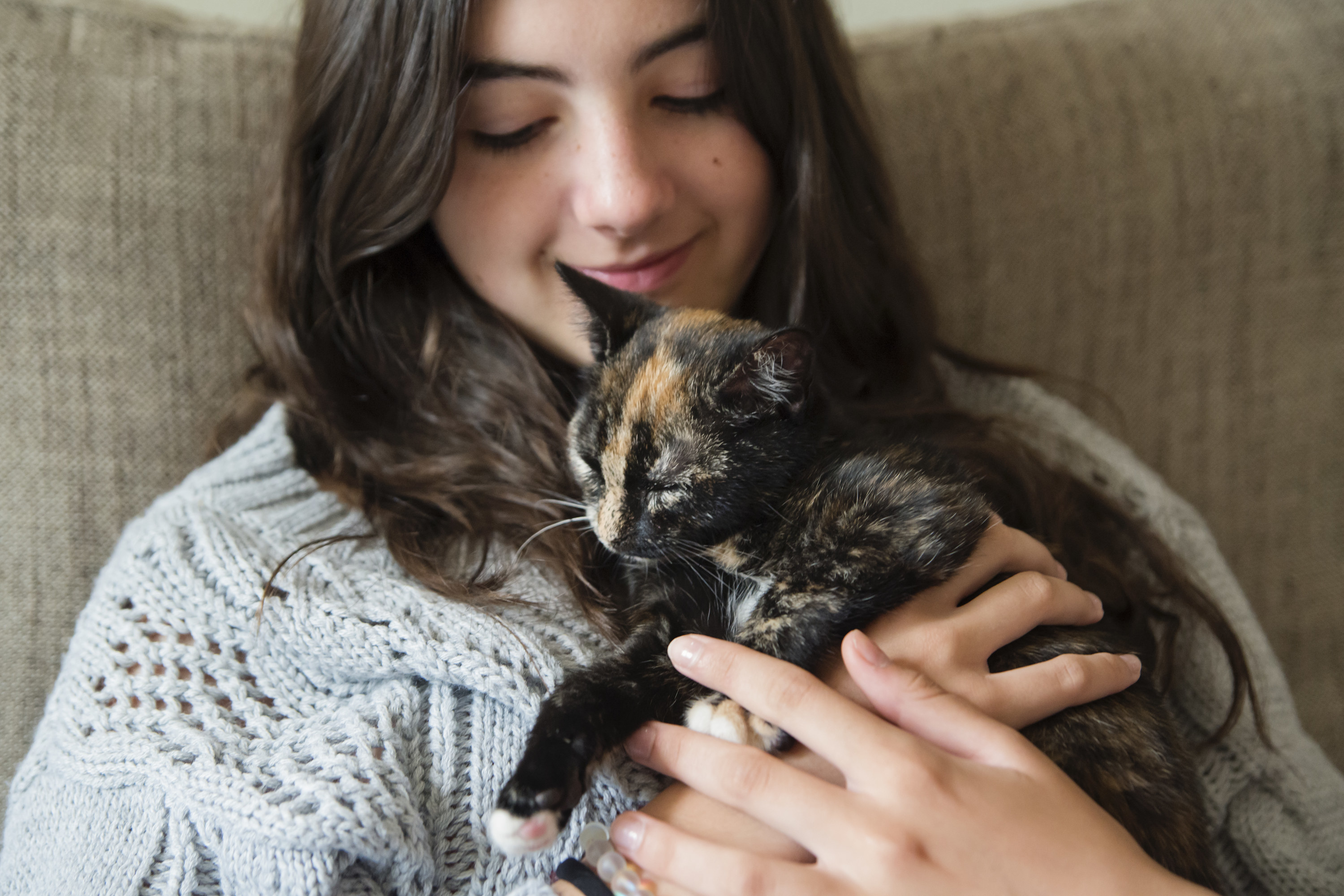 Young woman holding a cat close to her chest
