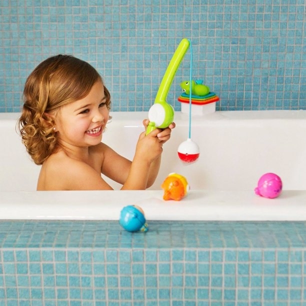 kid playing with fishing rod in the bath