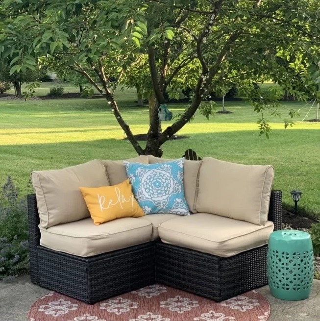 yellow and blue pillows on beige and black patio bench