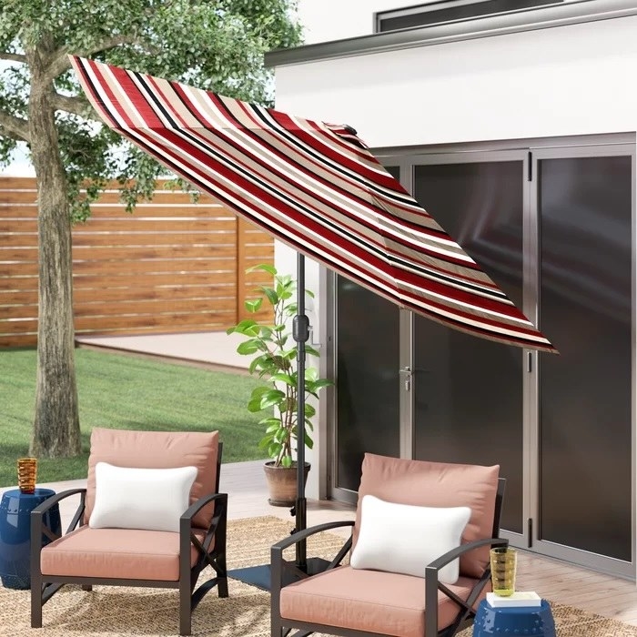 striped tilted umbrella over two patio chairs