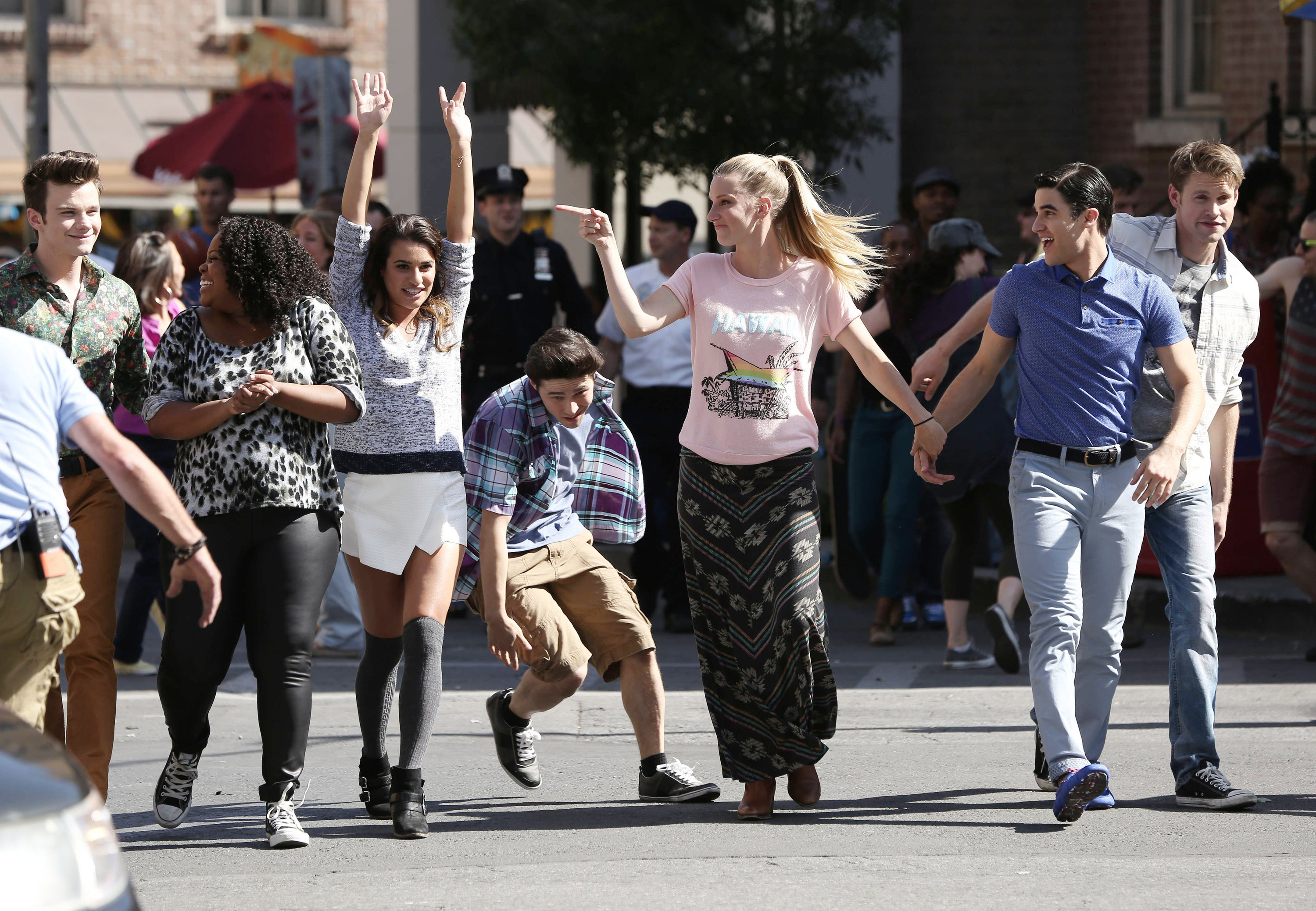 the cast dancing and walking down the street