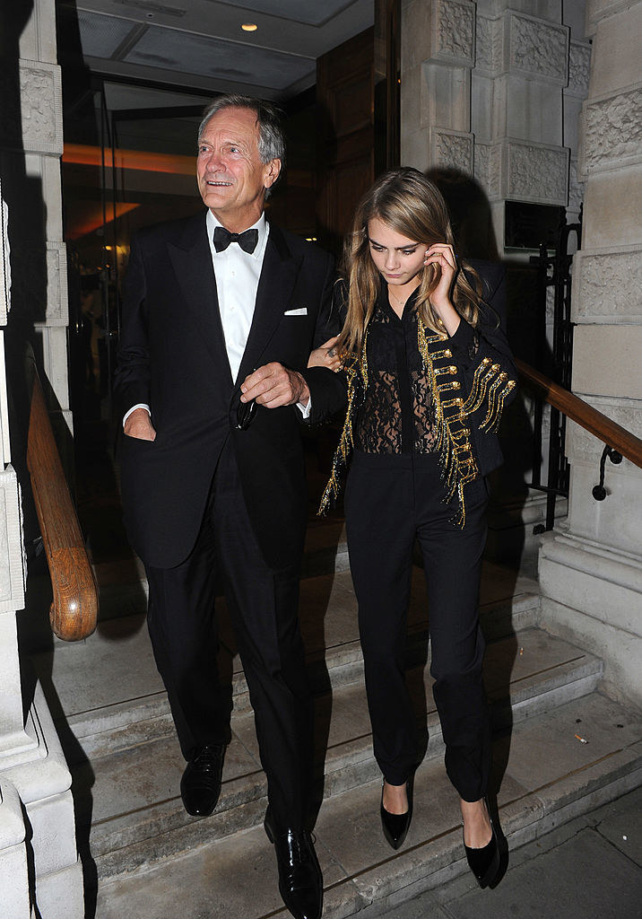 Cara walking down steps arm in arm with an older. man