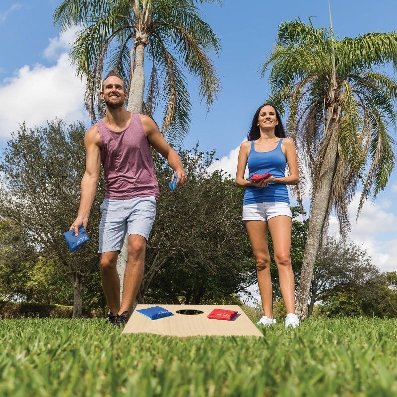 Male and female playing bean bag toss game