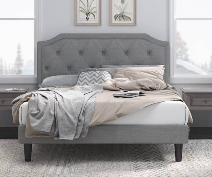 A grey upholstered platform bed