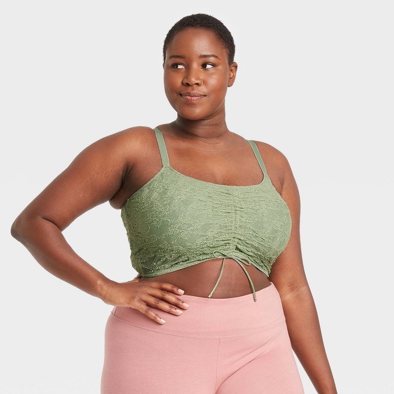 Model wearing green bralette and pink pants
