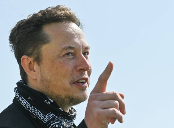 Elon Musk with his finger in the air