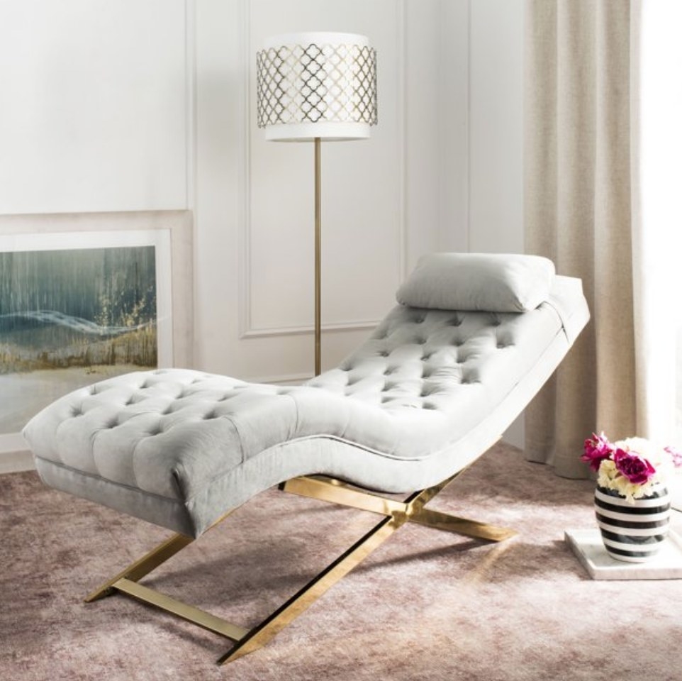 A grey/gold chaise lounge in a bedroom