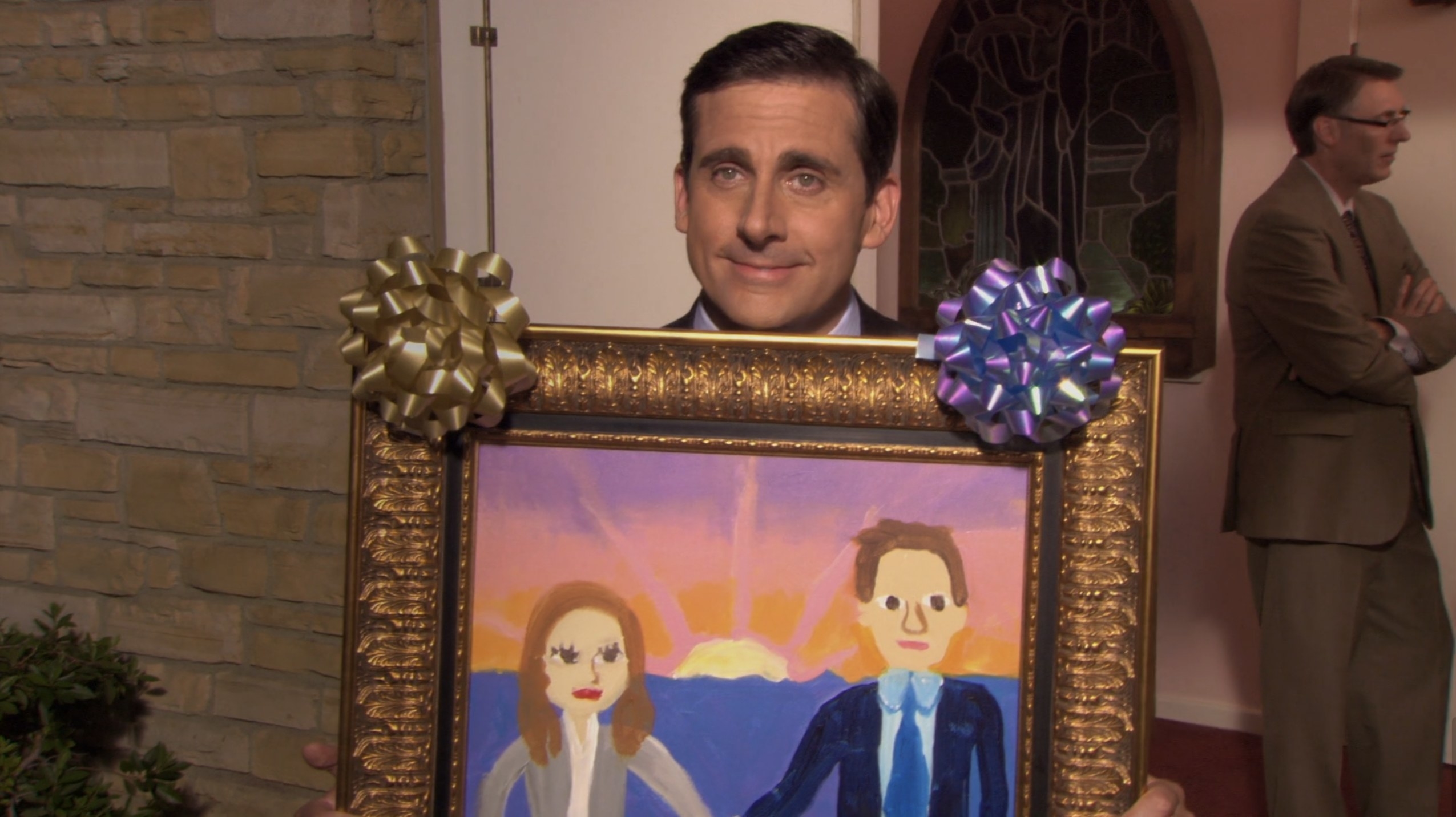 Michael Scott holding up his painting of Jim and Pam on The office