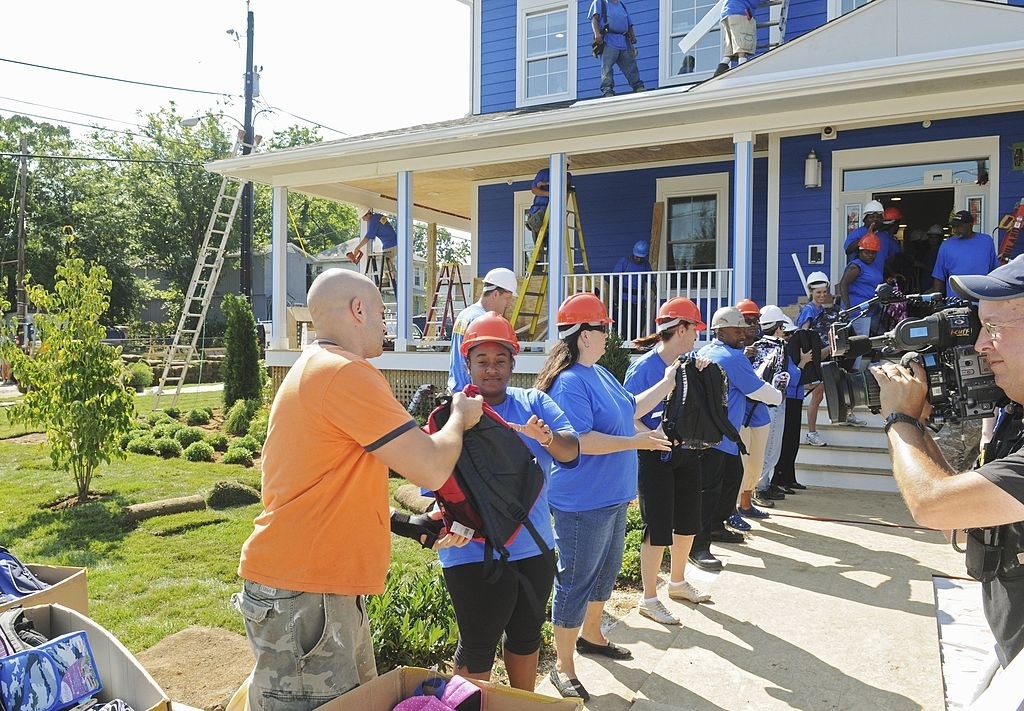 a team of neighbors helping bring item into the new house