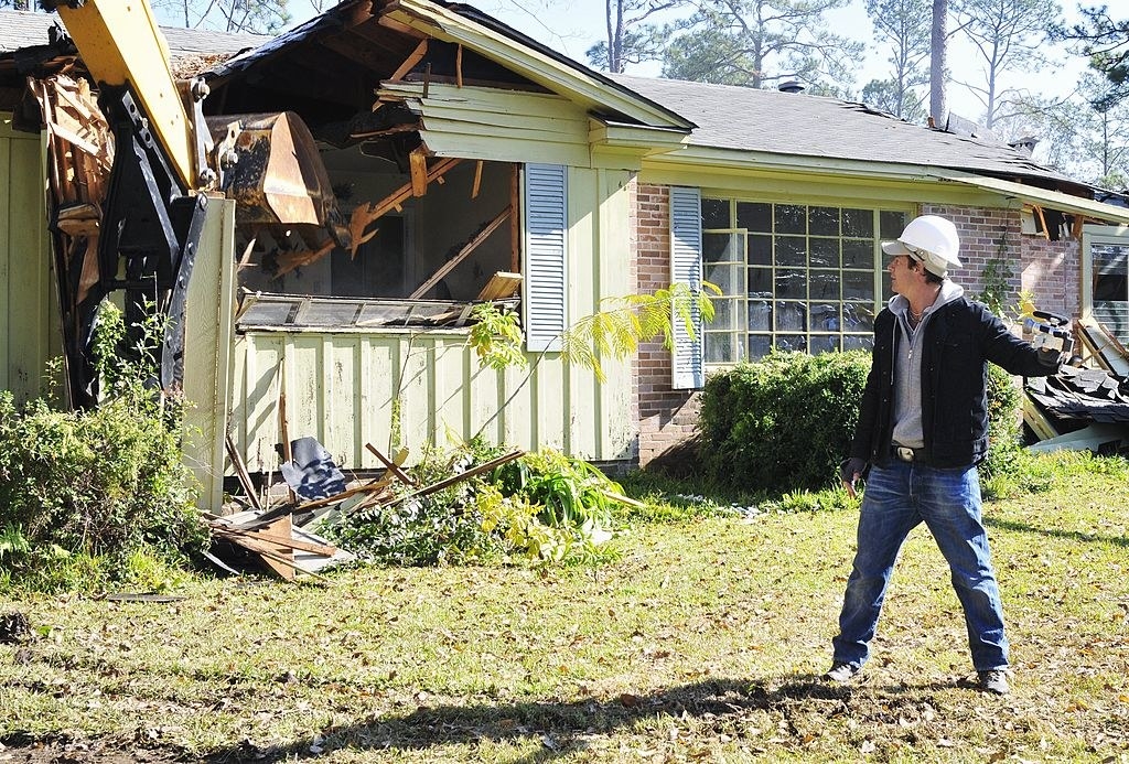 Ty looking on as a home gets demolished