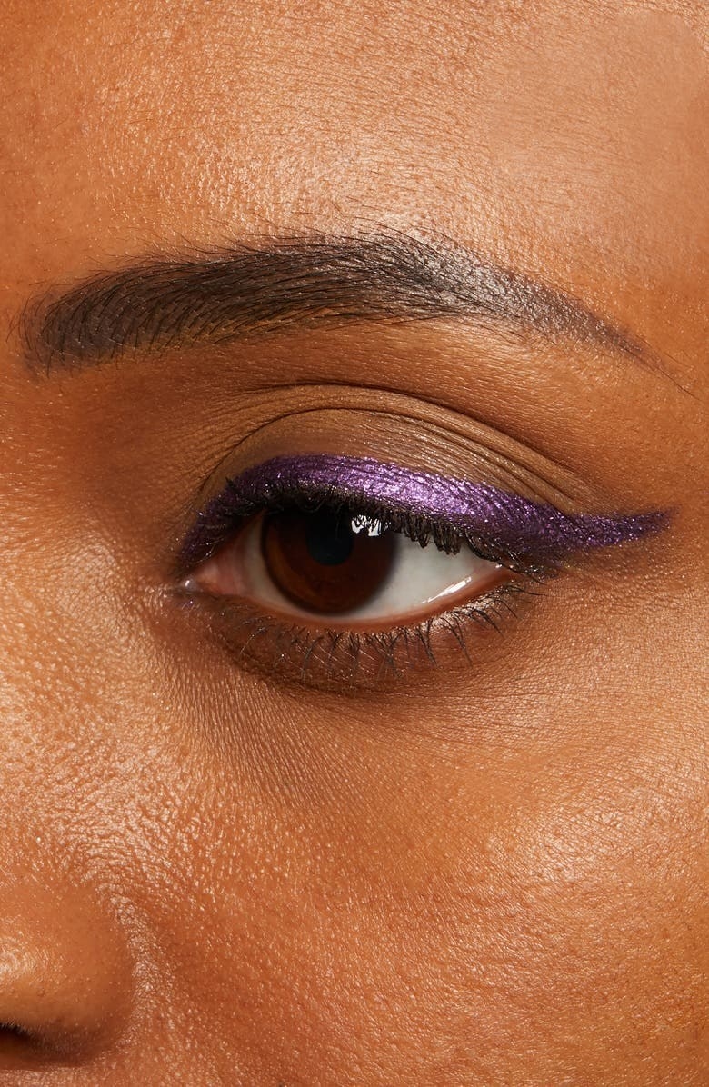 A person wearing shimmery purple eyeliner
