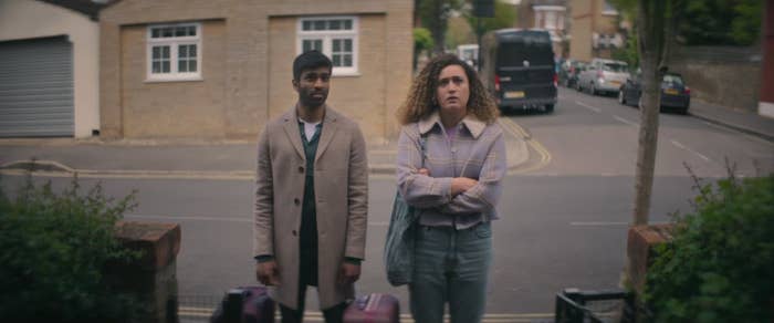 Rose Matafeo and Nikesh Patel stand in front of a house