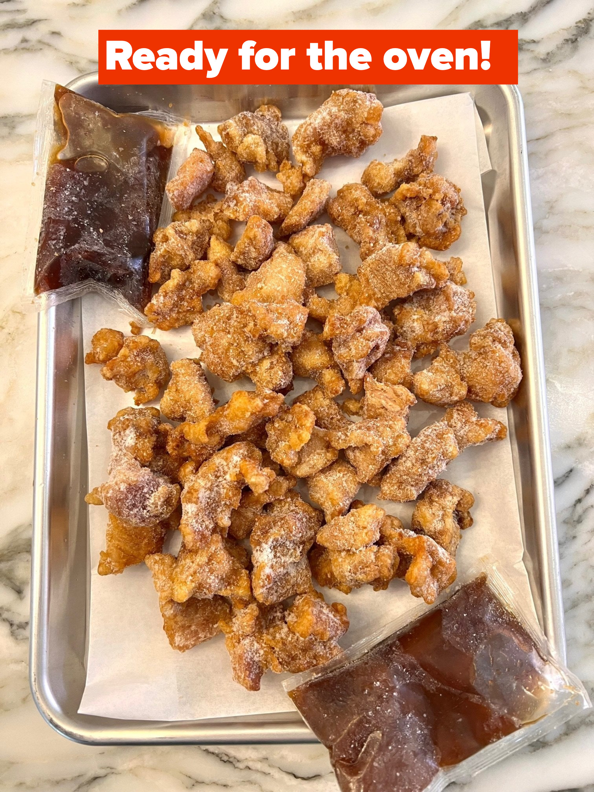 Frozen chicken pieces on a lined baking sheet