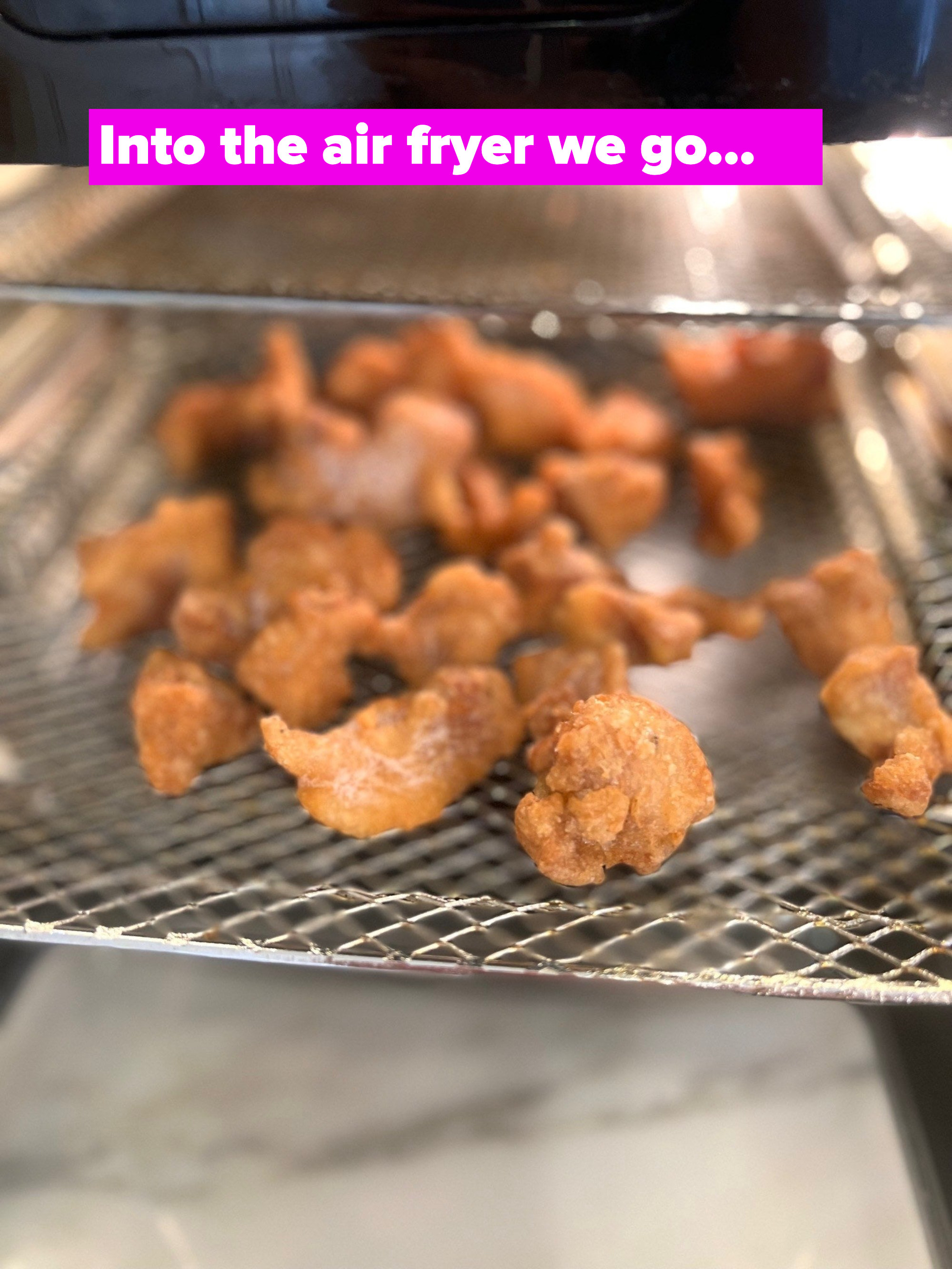 Pieces of breaded chicken in an air fryer.