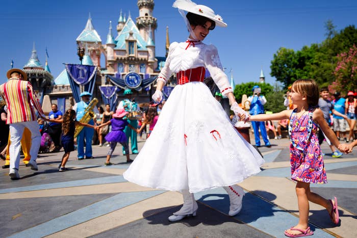 Small children and adults, including &quot;Mary Poppins,&quot; having fun in Disneyland