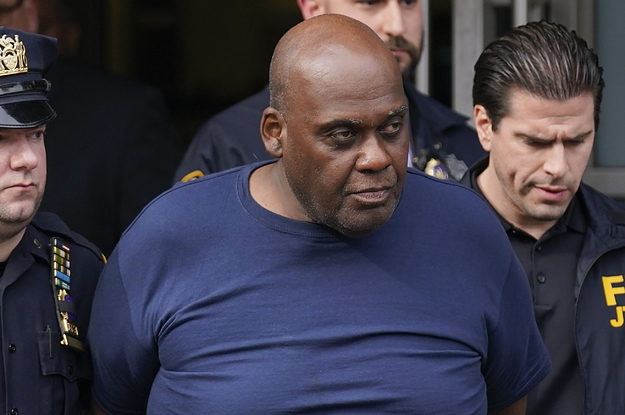 Frank James is escorted out of a building with his hands handcuffed behind him by police