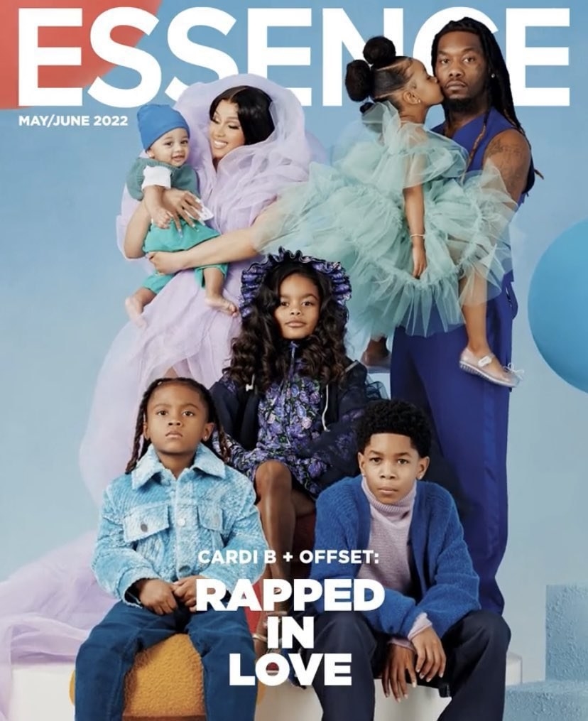 Cardi B holds her 7-month-old son in her arms, while Offset carries his daughter, who is kissing his cheek. Their other daughter and 3 sons pose in front of them, staring straight into the camera.