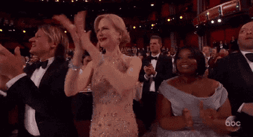 A GIF of Nicole Kidman clapping by just pressing her palms together, her fingers splayed far away from each other