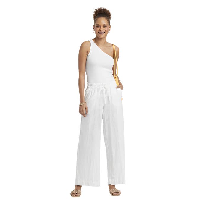 A woman wearing the linen pull-on pants with a white one-shoulder top