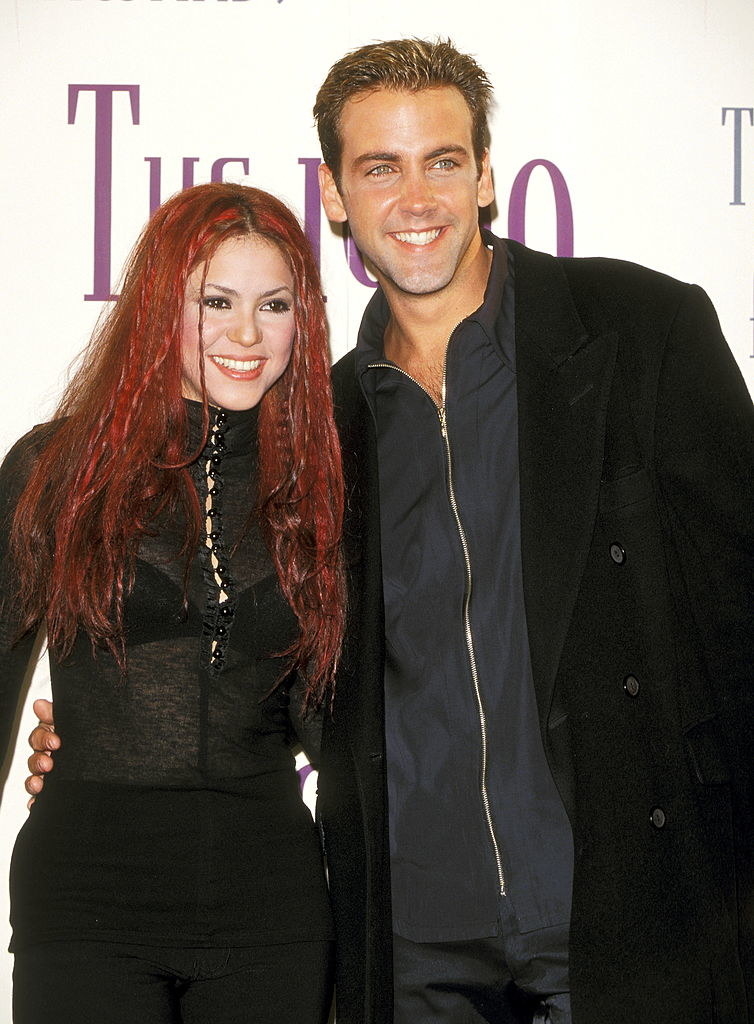 Shakira standing for a picture with a man with dyed red hair