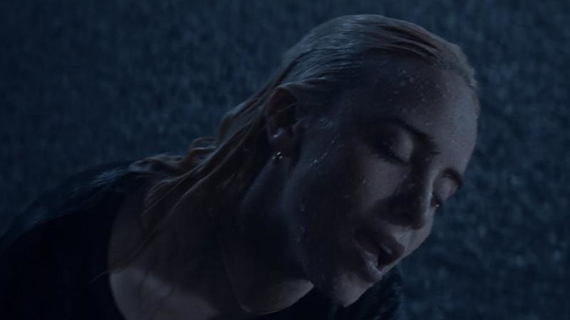 A close up of Billie Eilish as she stands in the rain