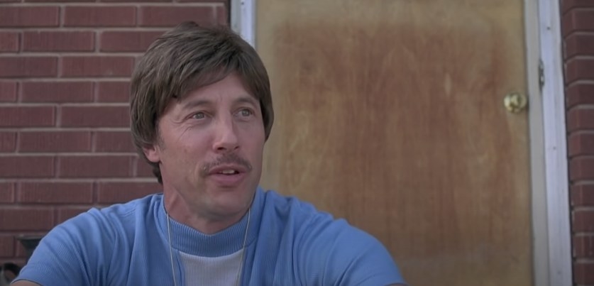 Uncle Rico sits on a stoop