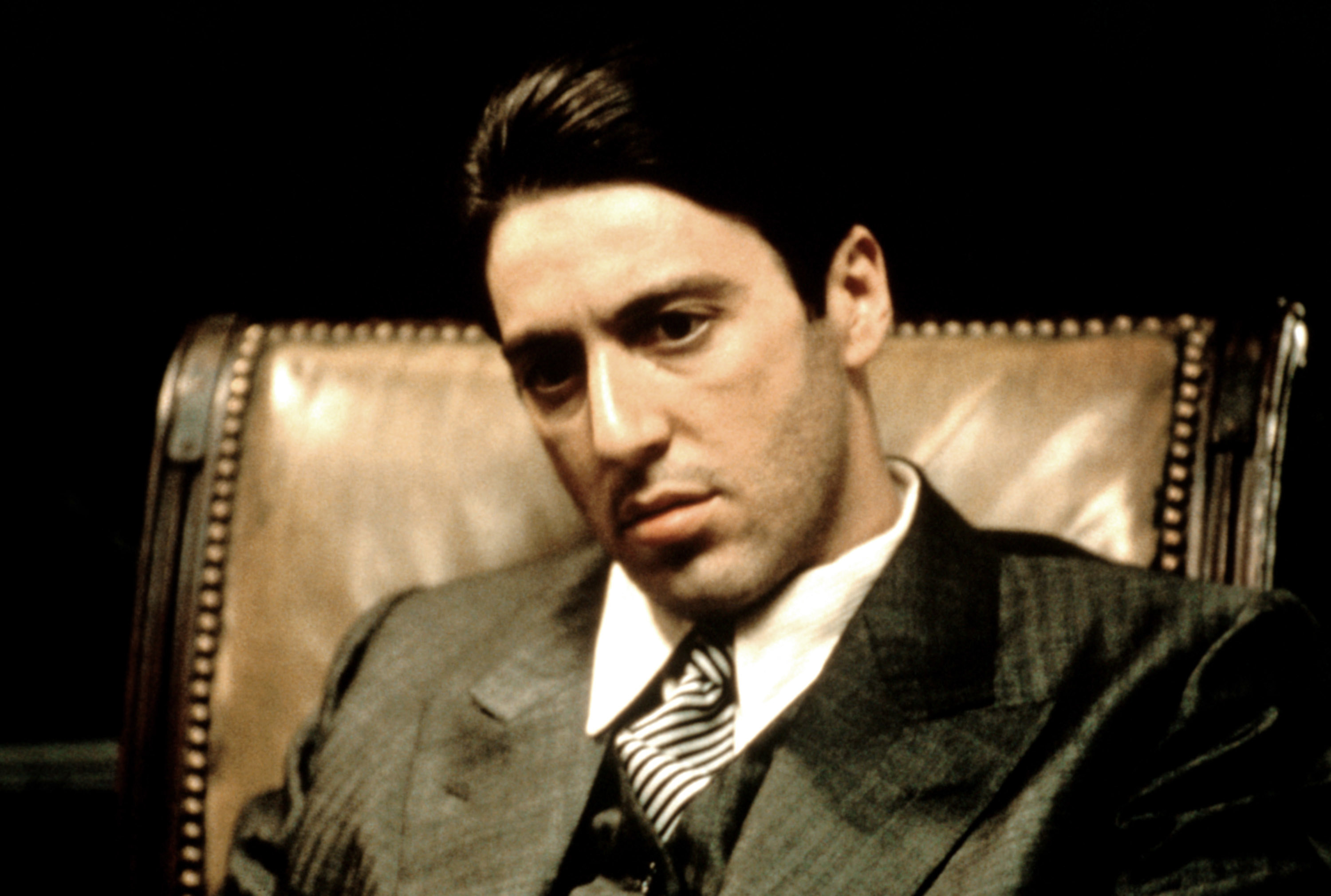 Michael Corleone sitting in a fancy office chair looking serious